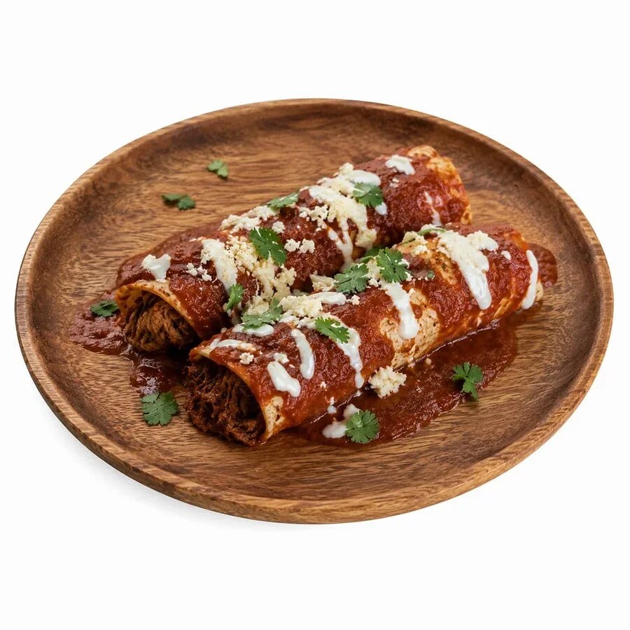 Two enchiladas under red sauce topped with crema and queso fresco on a wooden plate